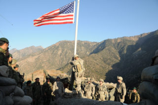 A noncommissioned officer with Troop C, 1st Squadron, 32nd Cavalary Regiment, prepares to lower the American flag during a transfer of authority ceremony at Observation Post Mace, as U.S. and Afghan National Army Soldiers look on. The ANA assumed control of OP Mace from the U.S. Army on Dec. 20. OP Mace is the northernmost observation post in Afghanistan's Kunar Province, which borders Pakistan. It is the first significant installation in the province for which ANA forces have assumed complete responsibility. ANA soldiers now safeguard the post and surrounding area, in accordance with the way ahead laid out in the Lisbon Plan to transfer security responsibility to Afghan forces. (U.S. Air Force Photo by Capt. Peter Shinn, Task Force Bastogne Public Affairs/RELEASED)